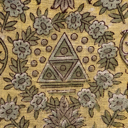 Close-up of a patterned fabric with floral and geometric designs on a yellow background