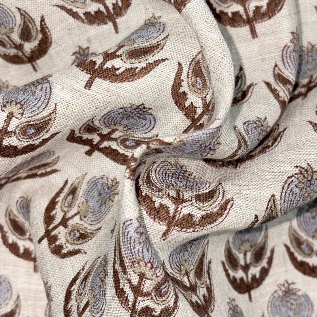 Close-up of fabric with brown and blue floral pattern on grey background
