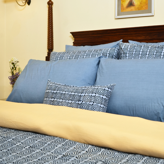 Blue and patterned pillows on a bed .