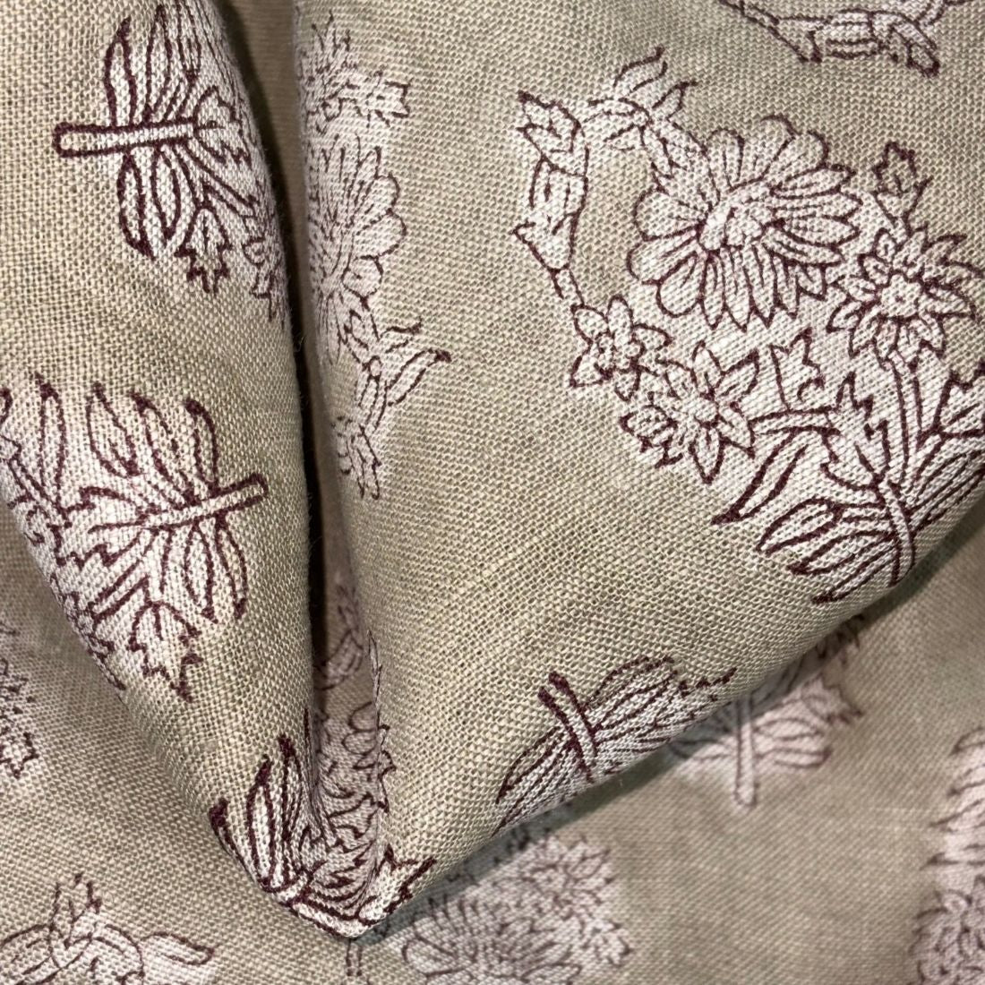 Close-up of fabric with floral and leaf patterns in brown on a grey background