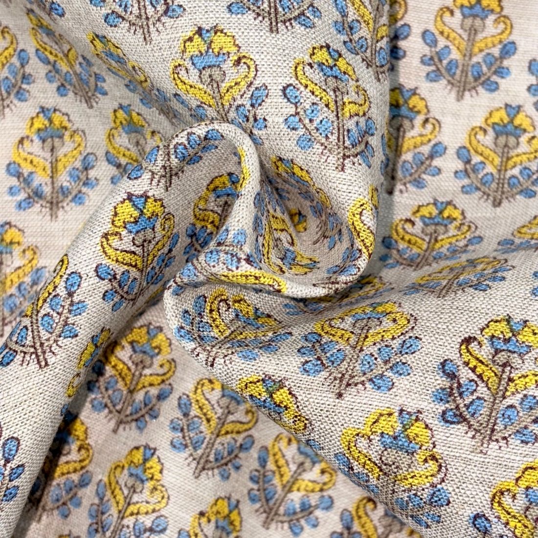 Close-up of patterned fabric with yellow and blue designs on a grey background
