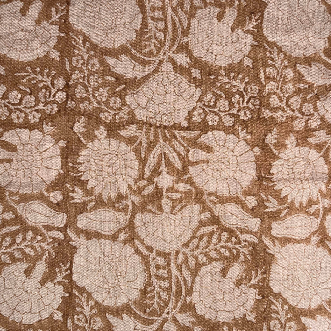 Floral patterned fabric with beige flowers on a brown background