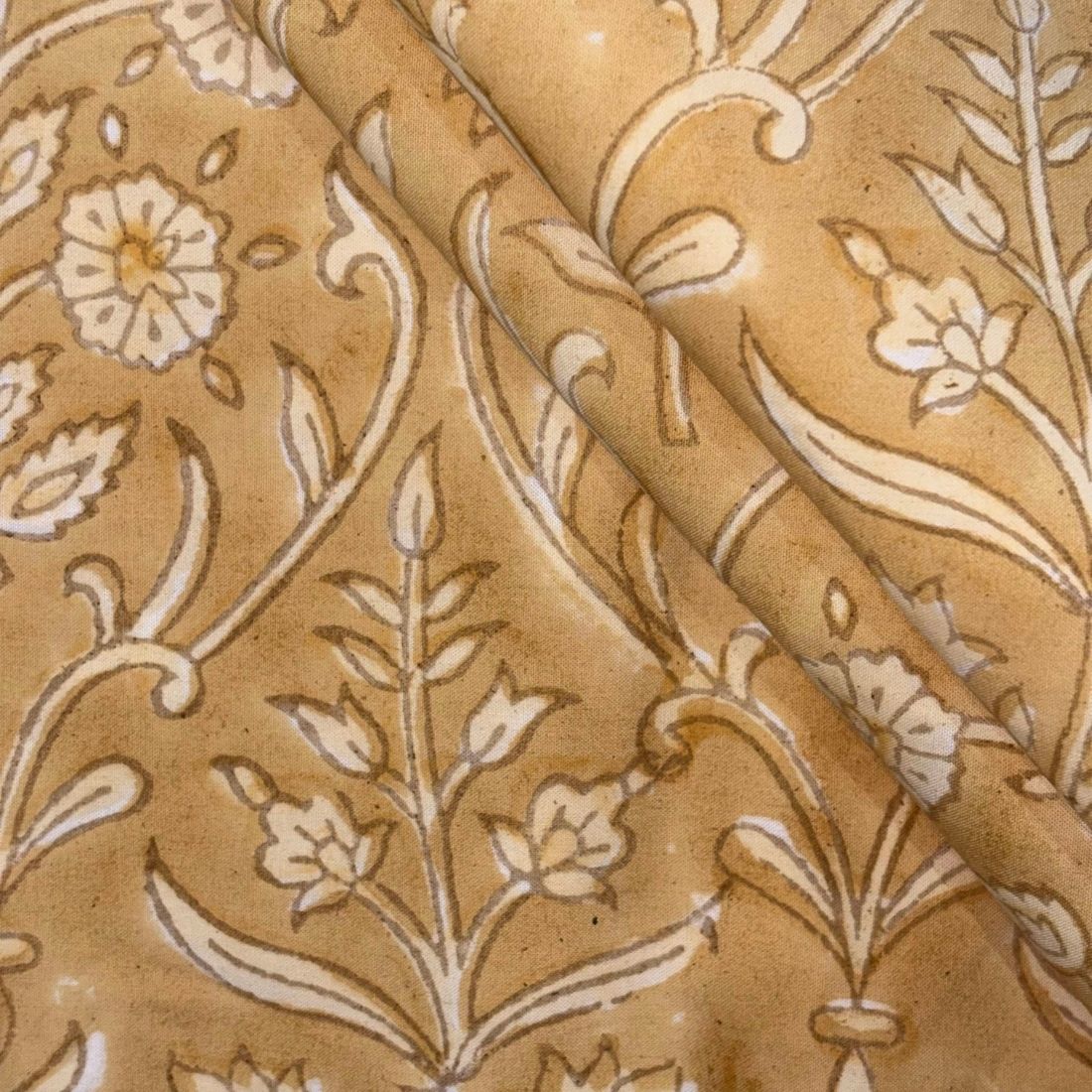Close-up of beige fabric with intricate floral and leaf pattern