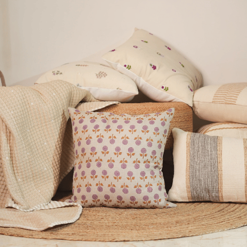 Decorative pillows with floral patterns on a woven surface