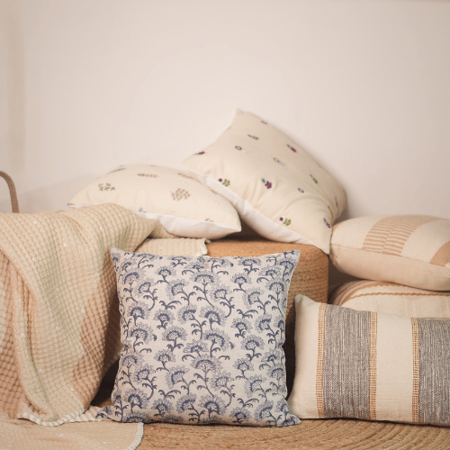 Collection of patterned pillows on a sofa against a neutral wall
