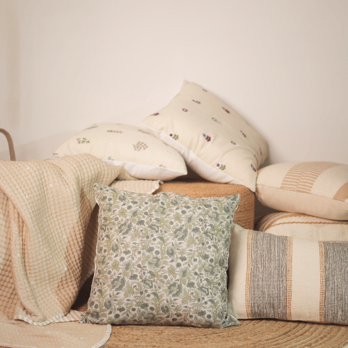 Stack of decorative pillows with floral patterns on a neutral background