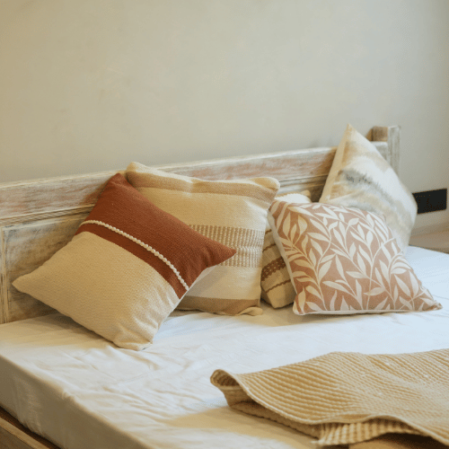Bed with decorative pillows and a blanket in a cozy bedroom setting
