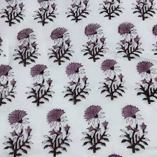 White fabric featuring a repeating block-printed pattern of purple and black thistle flowers.