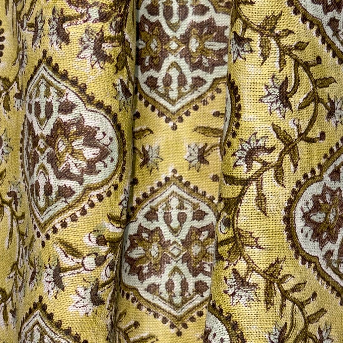 Close-up of a yellow fabric with brown and white geometric pattern