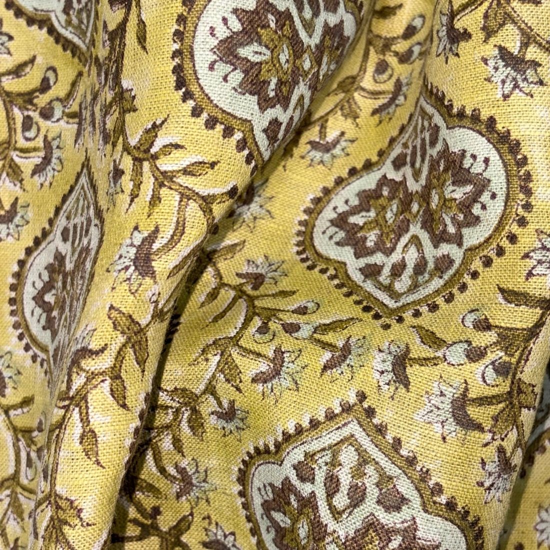 Close-up of yellow fabric with brown and white floral pattern