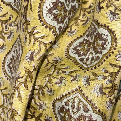 Close-up of yellow fabric with brown and white floral pattern