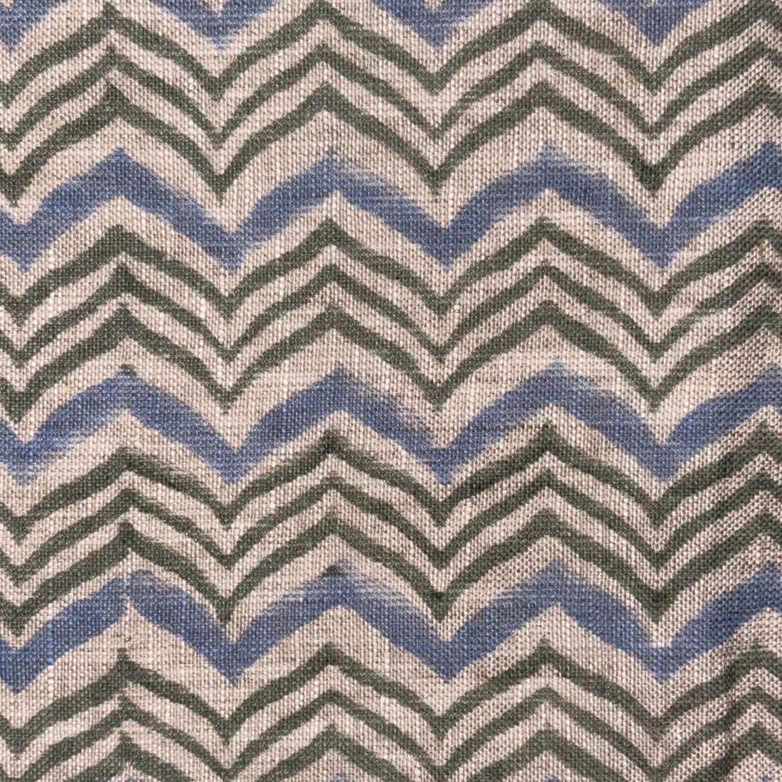 Fabric with zigzag pattern in blue, green, and gray on a neutral background