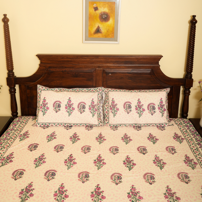 Floral patterned bedspread on a wooden bed with a decorative headboard.