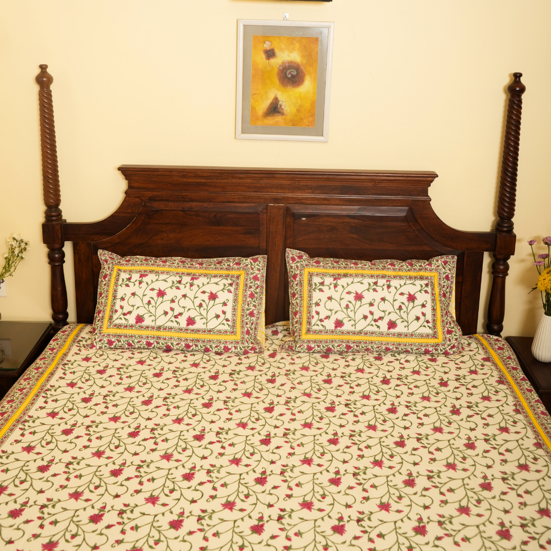 Floral patterned bedspread on a wooden bed with matching pillows.