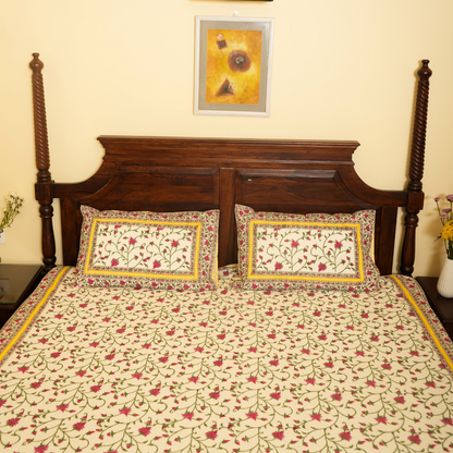 Floral patterned bedspread on a wooden bed with matching pillows.