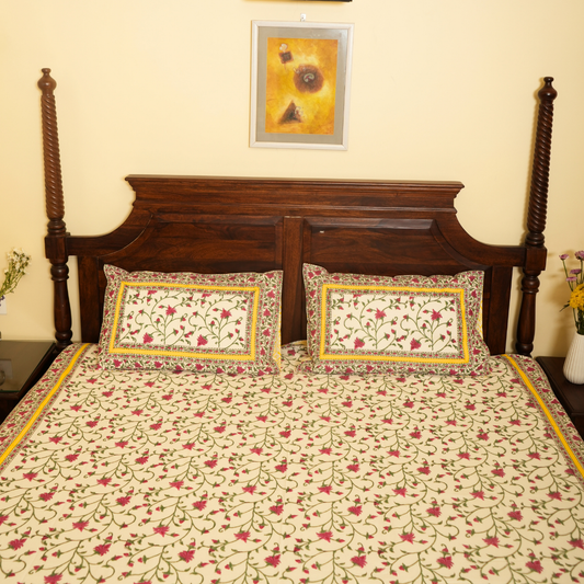 Floral patterned bedspread on a wooden bed with matching pillows.