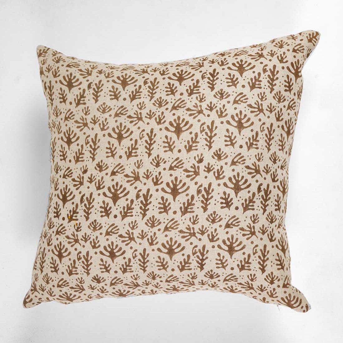 Decorative pillow with brown leaf pattern on a white background