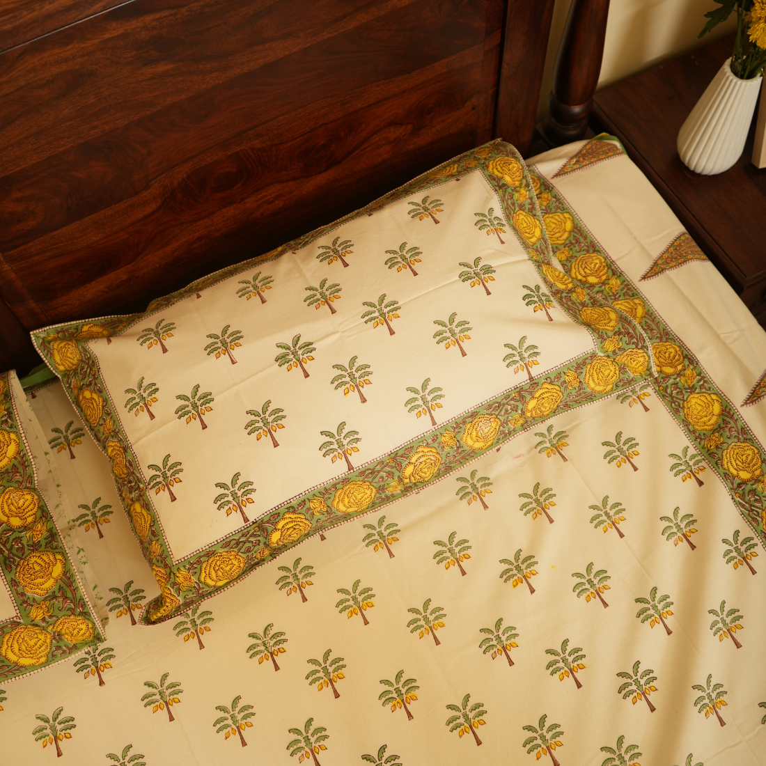 Beige bedspread with floral patterns on a wooden bed