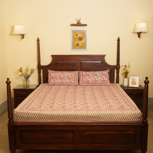 Wooden bed with patterned bedding in a bedroom setting.