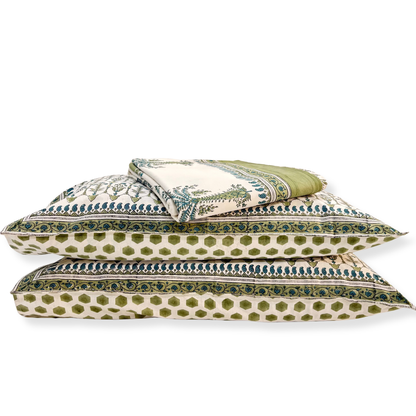 Set of green and white patterned pillows on a white background