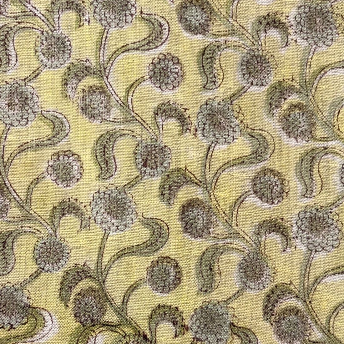 Floral patterned fabric with green and brown colors on a yellow background