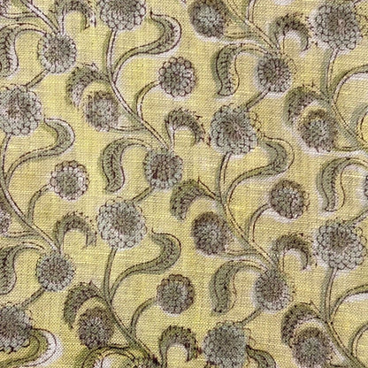 Floral patterned fabric with green and brown colors on a yellow background
