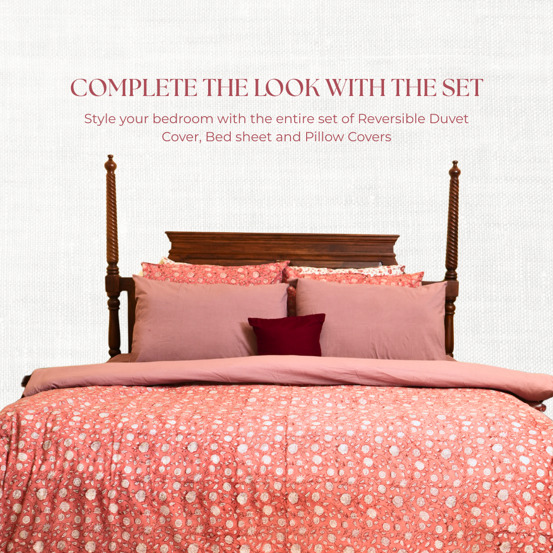 Bed with pink floral bedding and pillows on a white background, featuring text about reversible duvet cover sets.