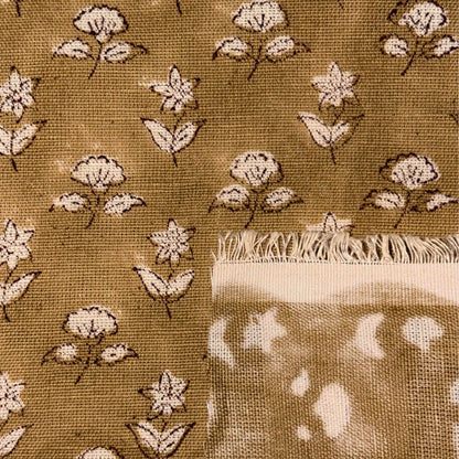 Textile with floral pattern and frayed edge on a brown background