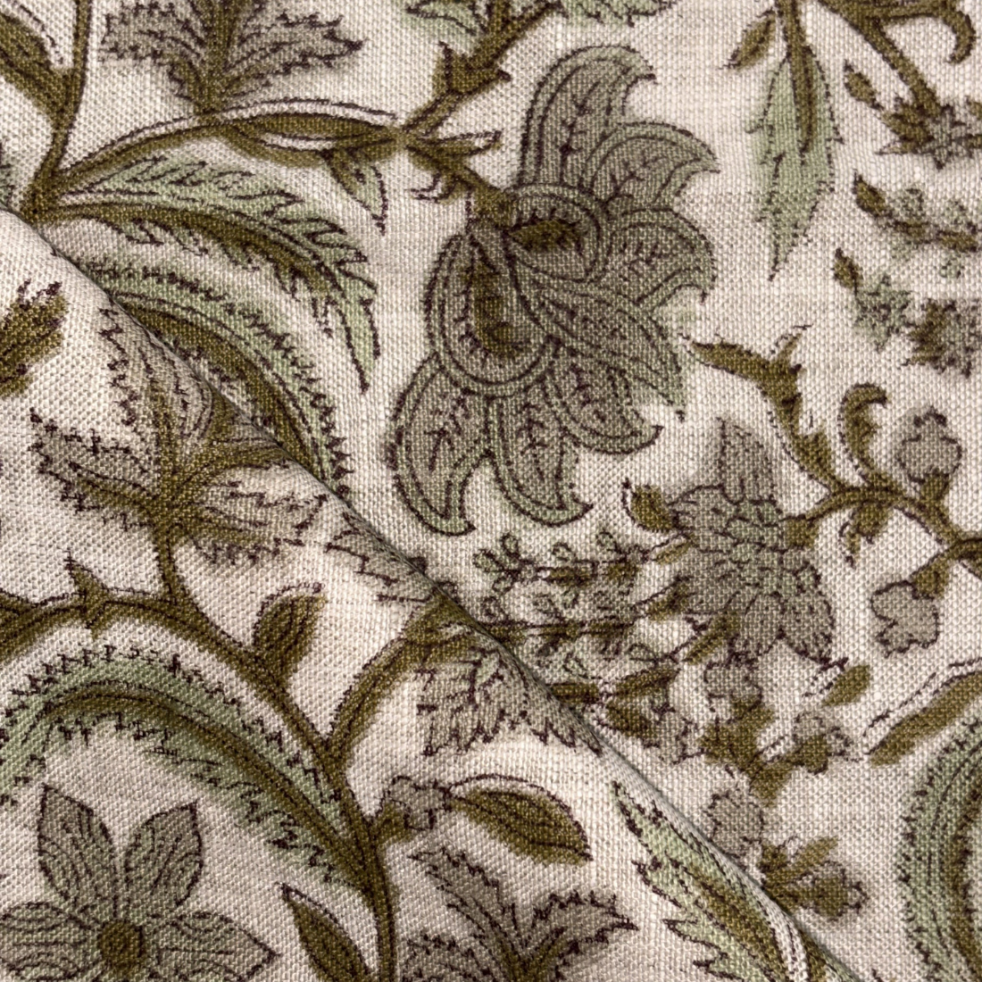 Close-up of a floral and leaf patterned fabric in brown on a grey background