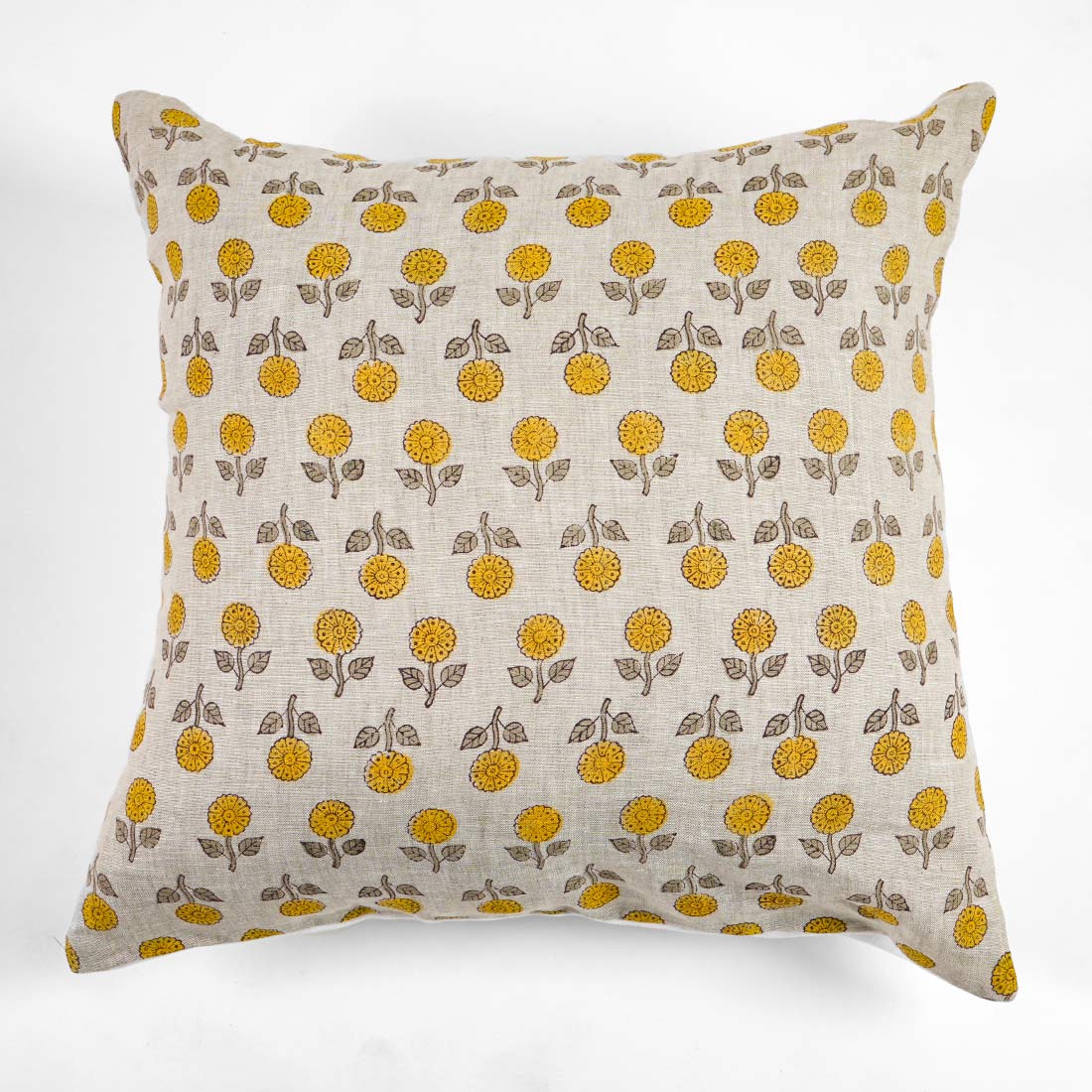 Block printed pillow with yellow floral pattern on a white background