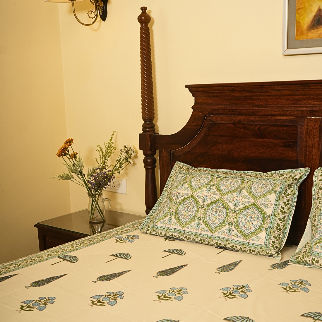 Bedroom with floral bedspread and decorative pillows on a wooden bed.