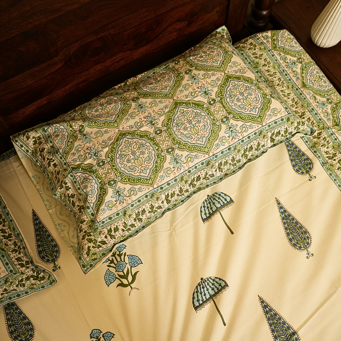 Decorative bedspread with intricate patterns on a wooden bed