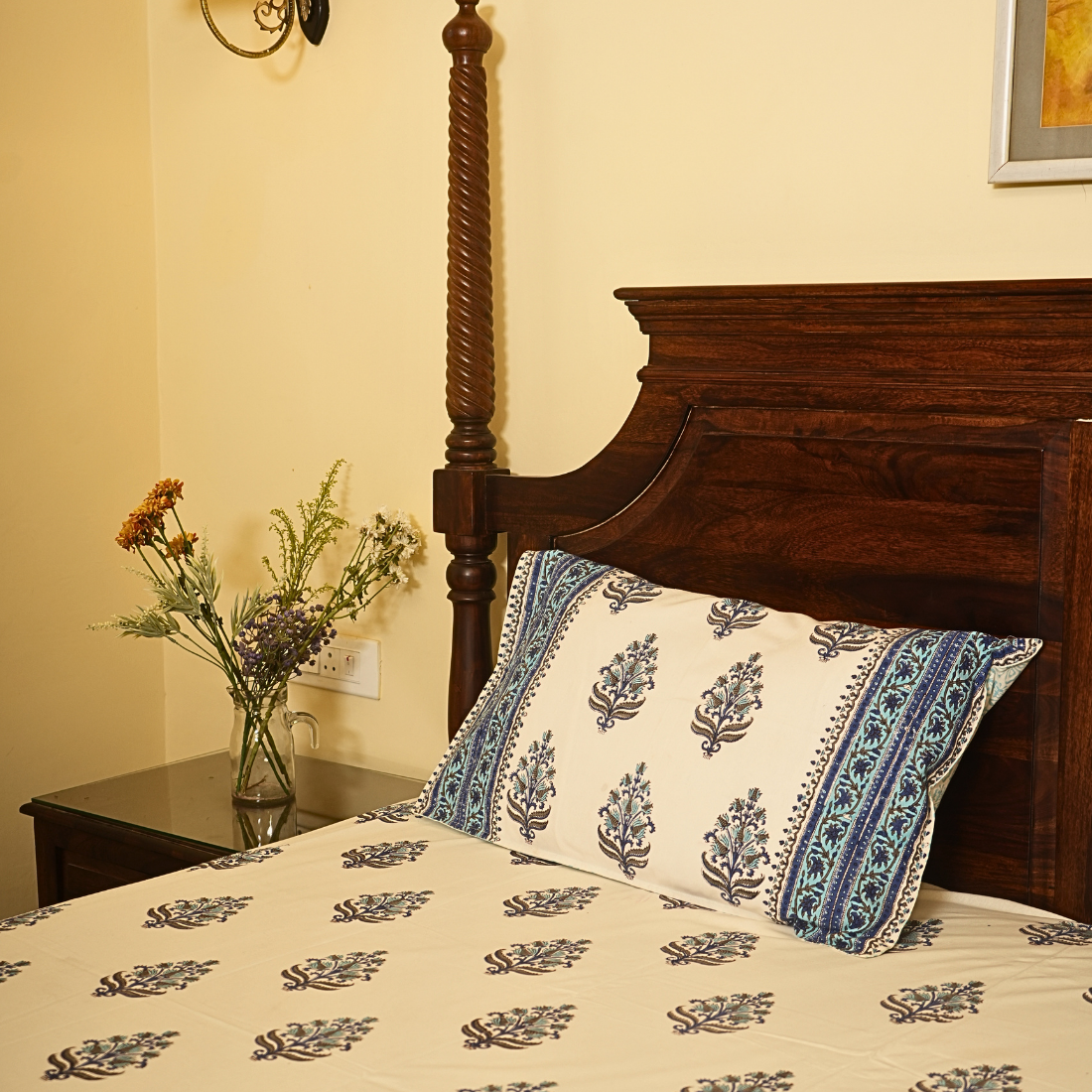 Bed with floral bedding and pillows in a bedroom setting.