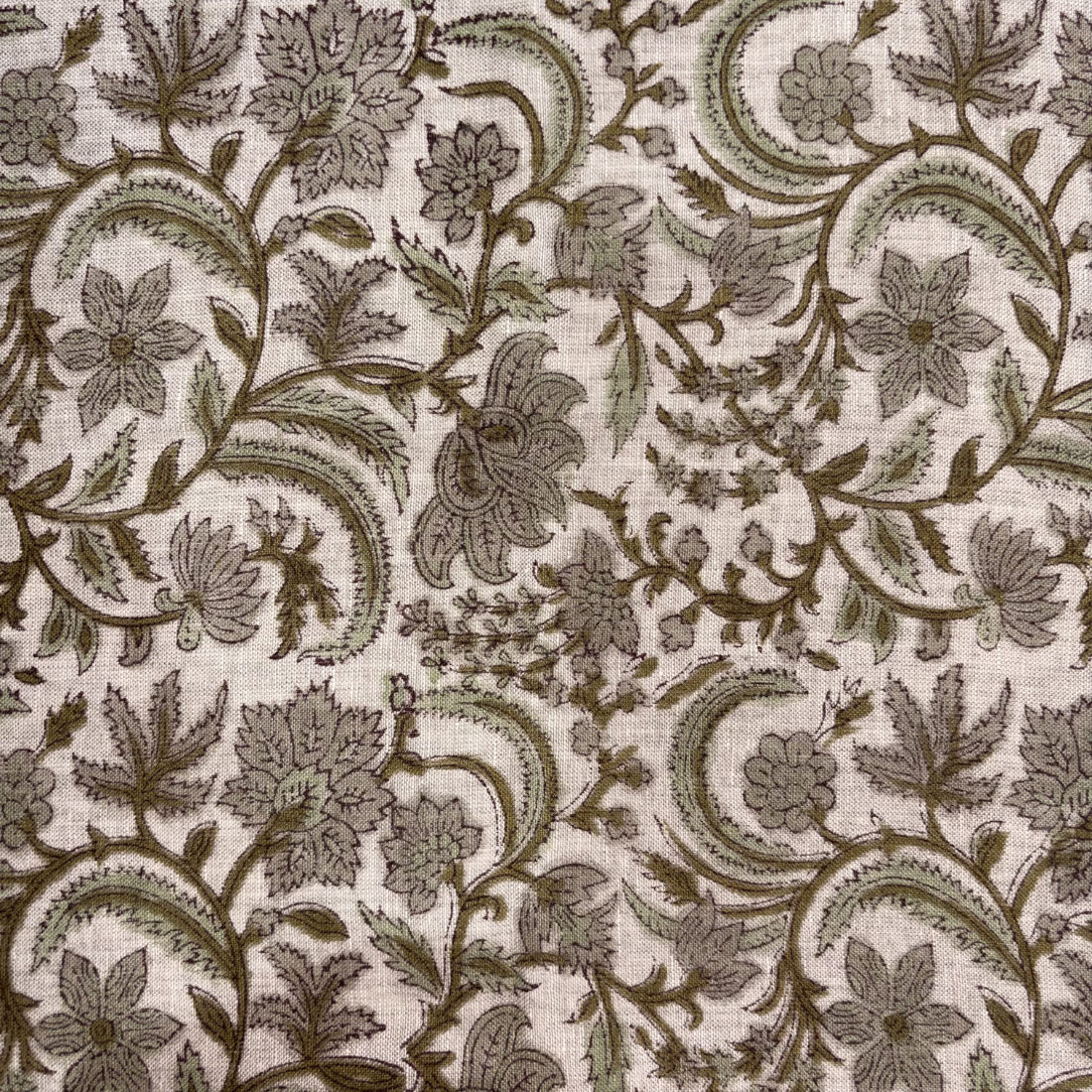 Floral and paisley patterned fabric in brown on a grey background