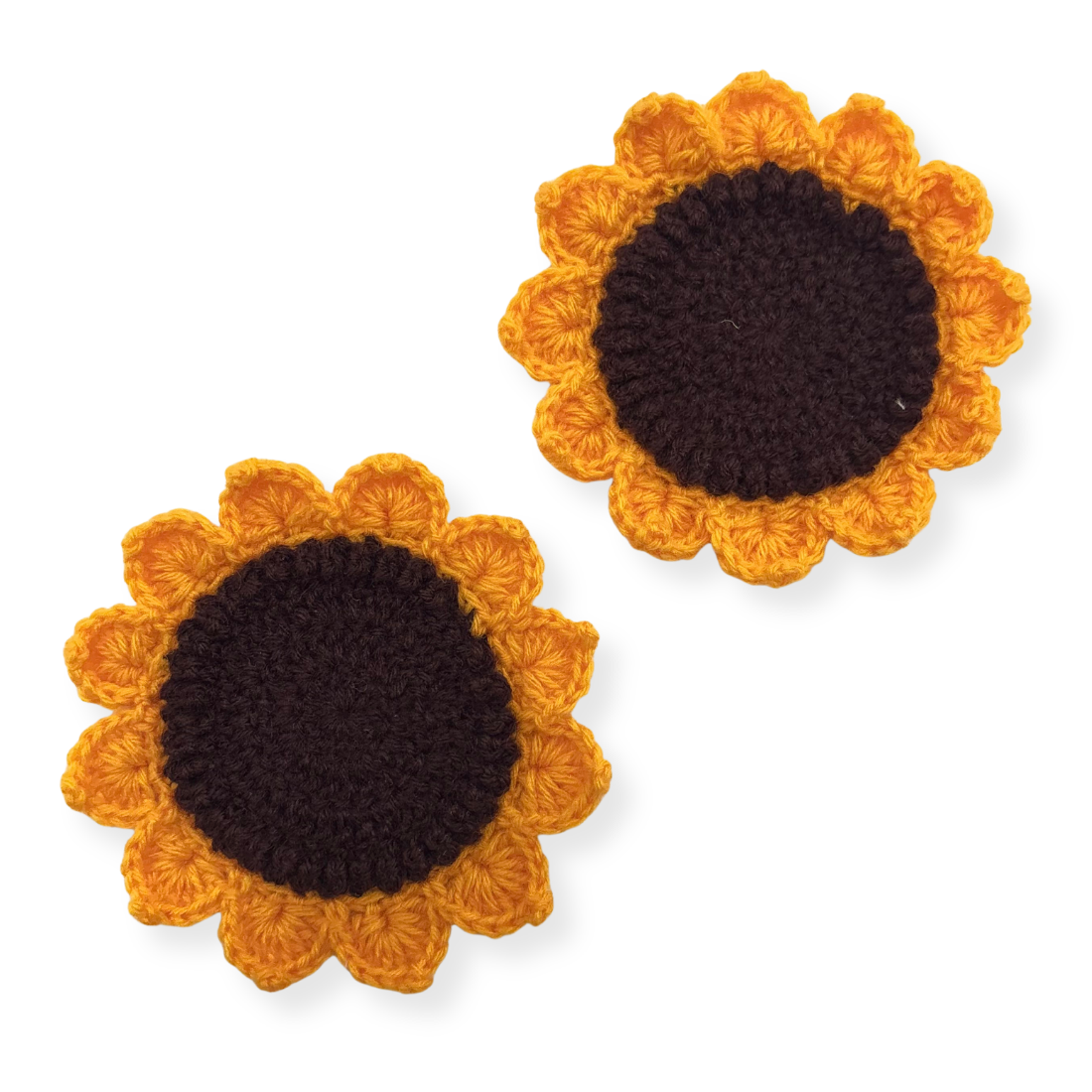 Two sunflower-shaped crochet coasters with brown centers and yellow petals on a white background.