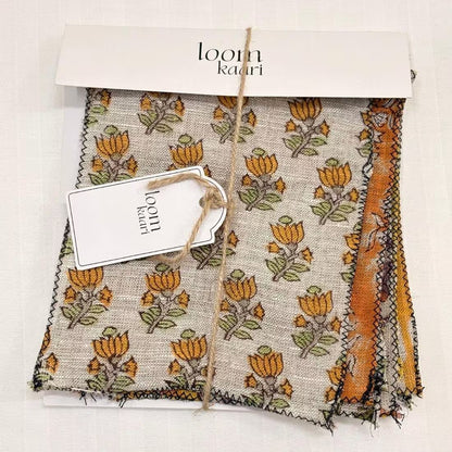 A bundle set of swatches a beige base with a repeating orange and yellow floral motif and a small orange embroidered accent on the right side.