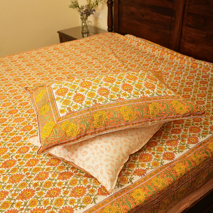 Decorative floral-patterned pillows on a bed with a matching bedspread.