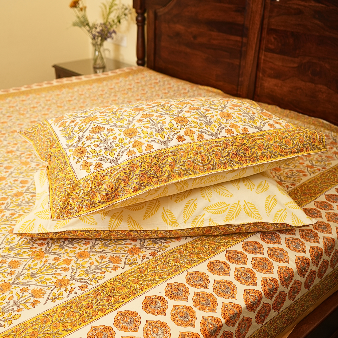 Decorative pillows with intricate patterns on a bed in a bedroom setting.