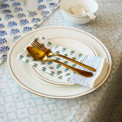 Table setting with gold cutlery on a patterned napkin
