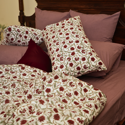 Floral-patterned bedding set on a bed with matching pillows.