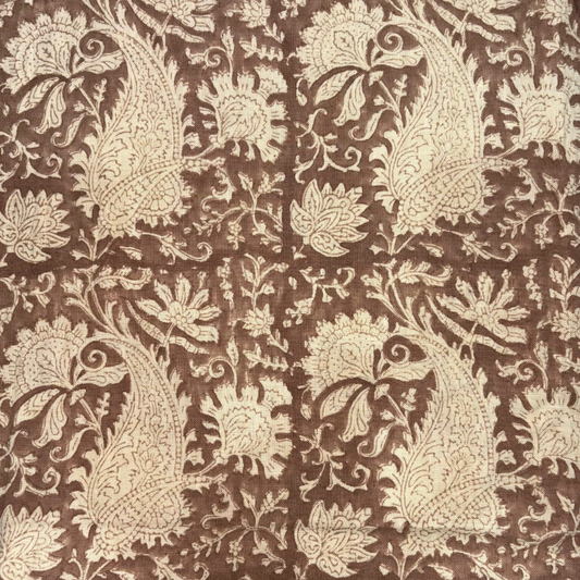 Patterned fabric with beige paisley design on a brown background