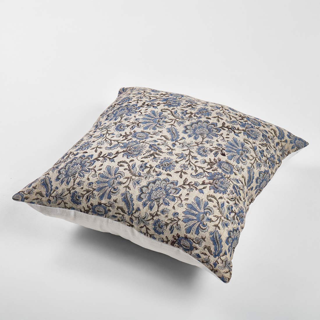Decorative pillow with blue floral pattern on a white background