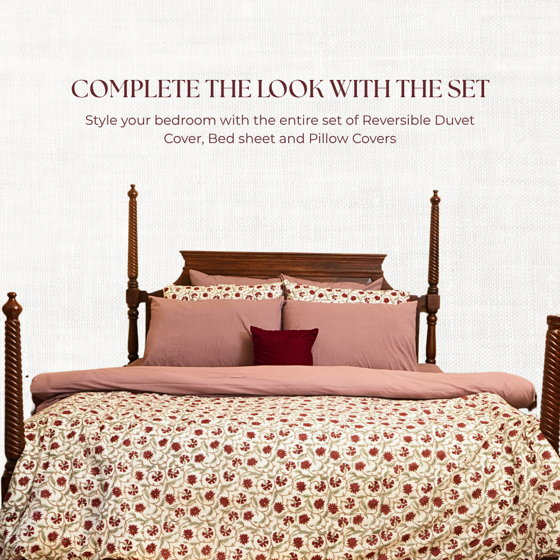 Bed with floral duvet and pillows on a white background.