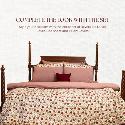 Bed with floral duvet and pillows on a white background.