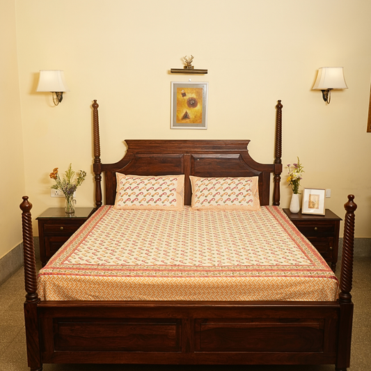 Wooden bed with patterned bedding in a bedroom setting.
