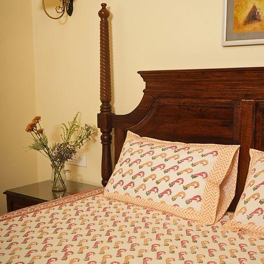 Bed with wooden headboard and patterned bedding in a bedroom setting.