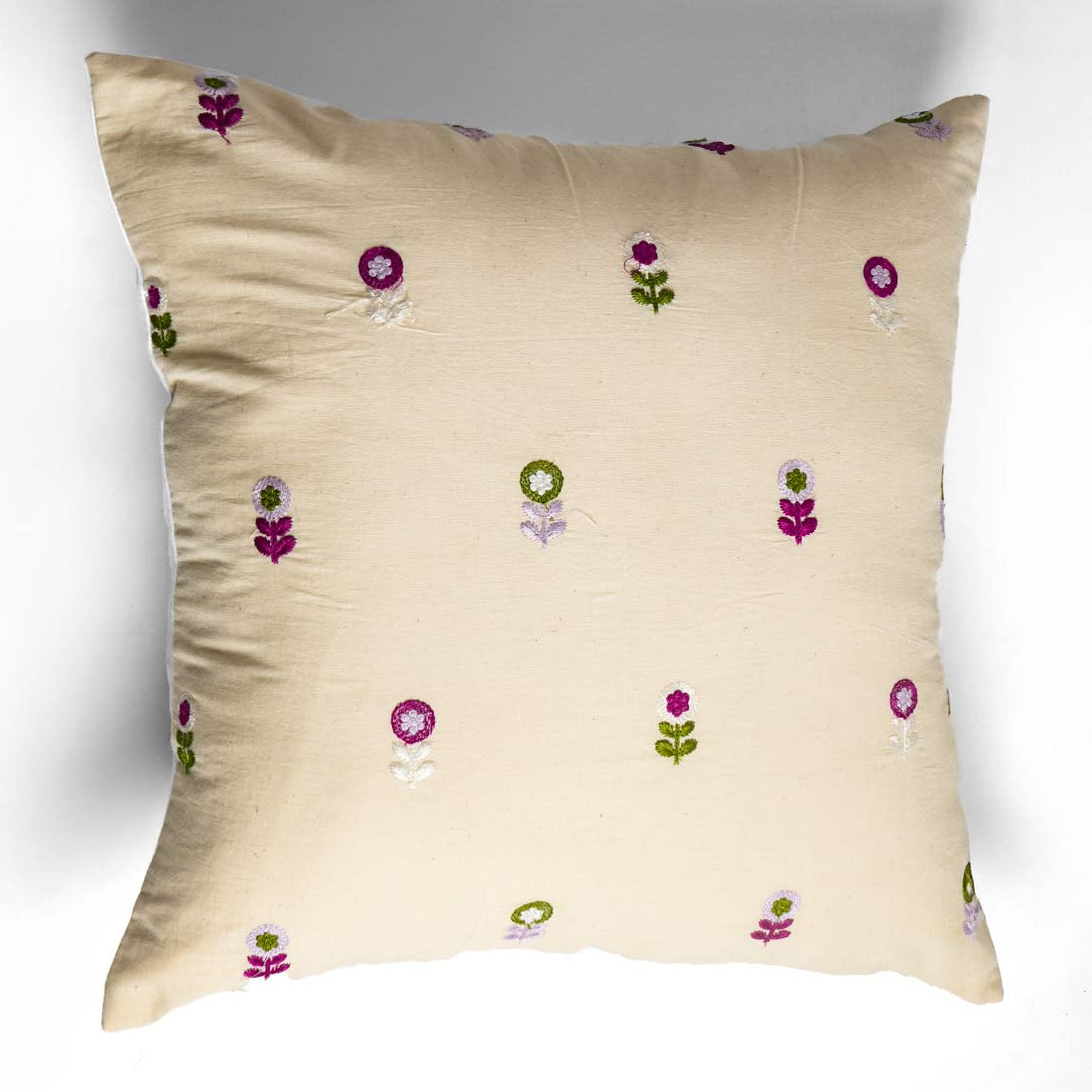 Beige pillow with floral embroidery on a white background