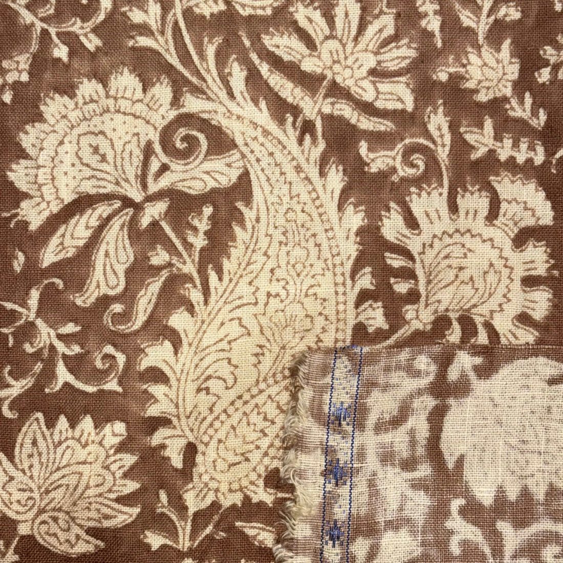 Close-up of brown fabric with beige floral pattern