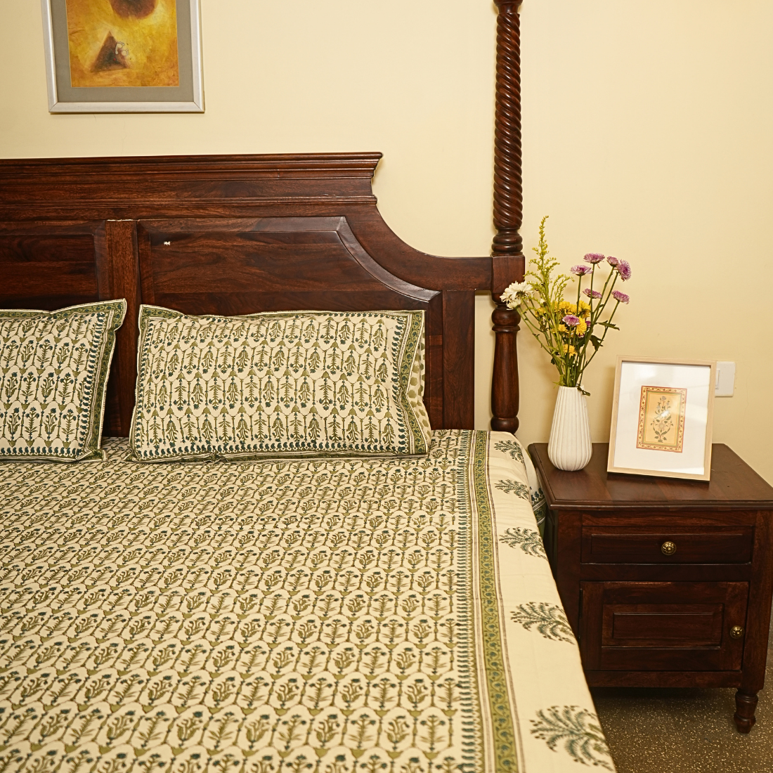 Bedroom with wooden bed, patterned bedding, and decorative items.