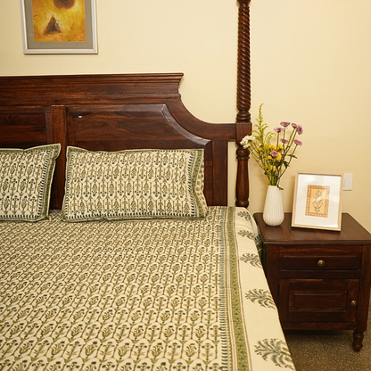 Bedroom with wooden bed, patterned bedding, and decorative items.